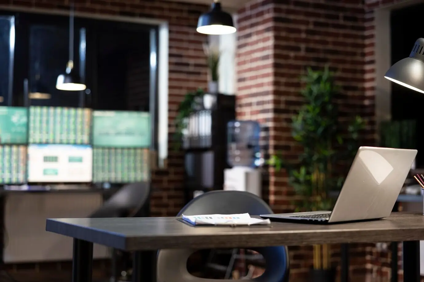 На пустом офисном столе — ноутбук и планшет для бумаг.