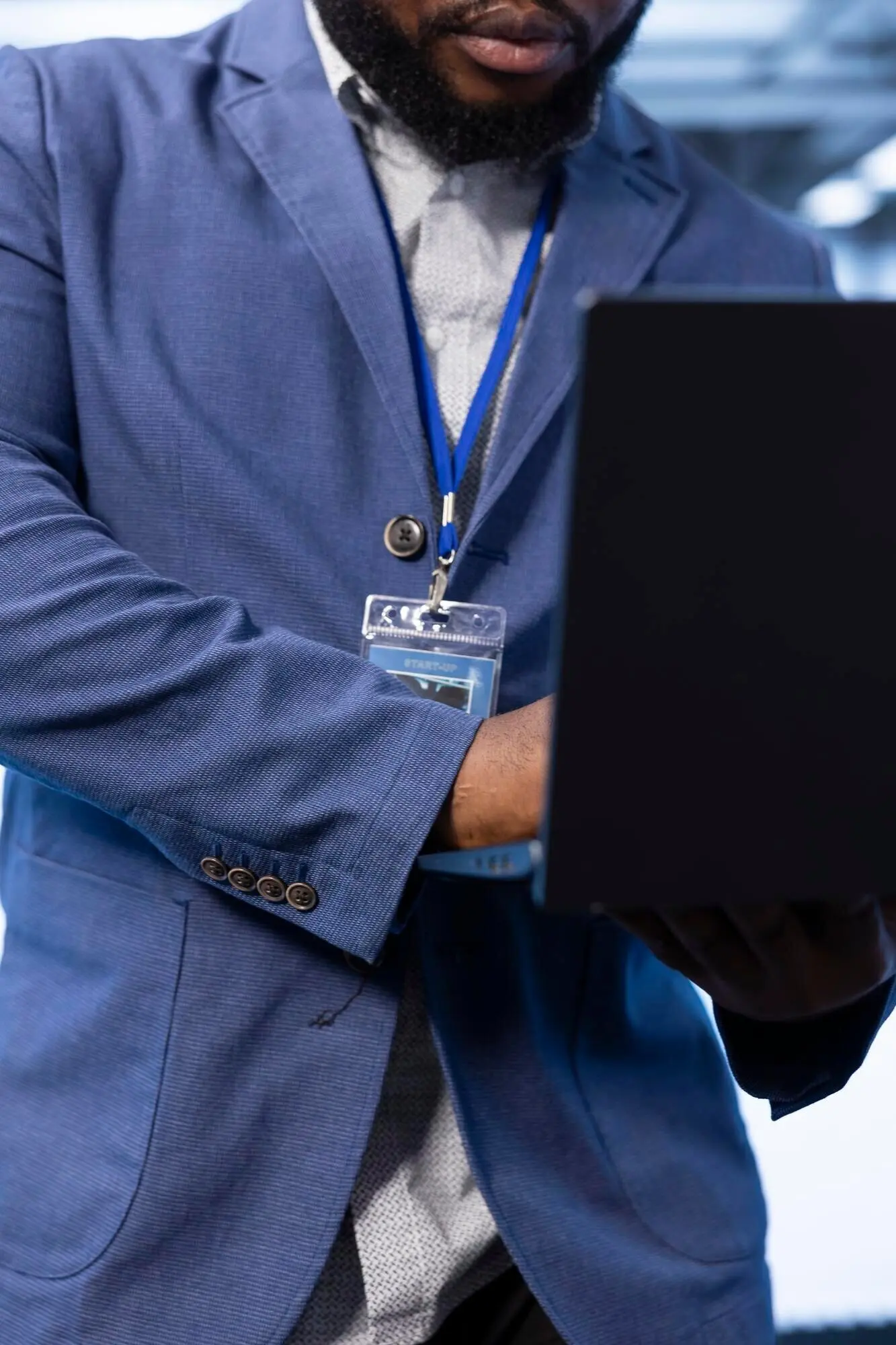 Крупный план работника серверной фермы, устраняющего ошибки на ноутбуке.