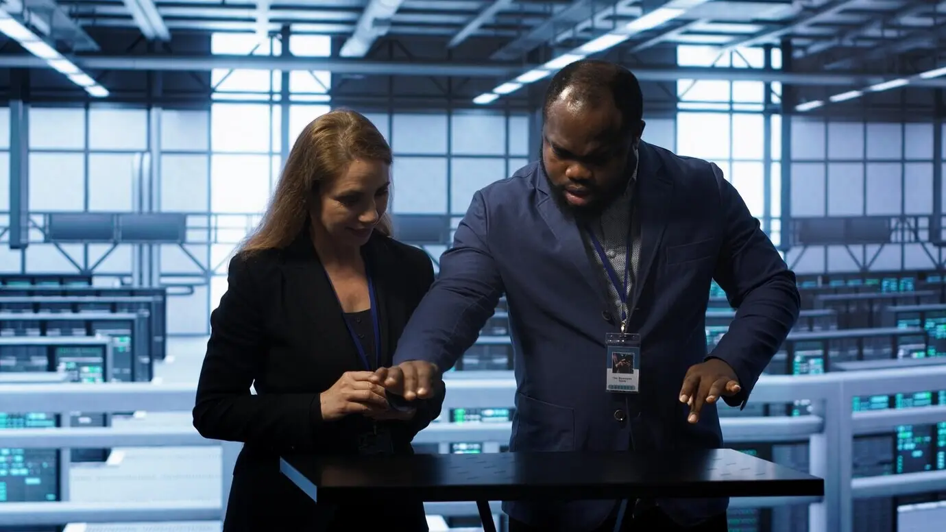 Сотрудники на рабочей площадке серверной фермы взаимодействуют с технологиями дополнённой реальности.